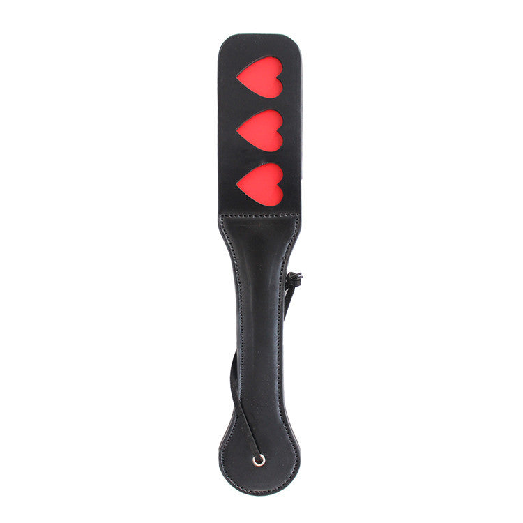 Paleta para nalgadas negra en forma de corazón de la marca juguitodecalzonco, abierta mostrando sus detalles.