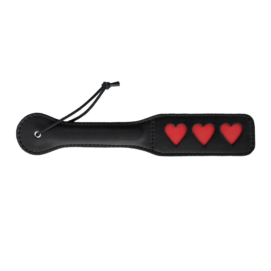 Paleta para nalgadas de color negro con diseño de corazón, marca juguitodecalzonco, cerrada y lista para usar.