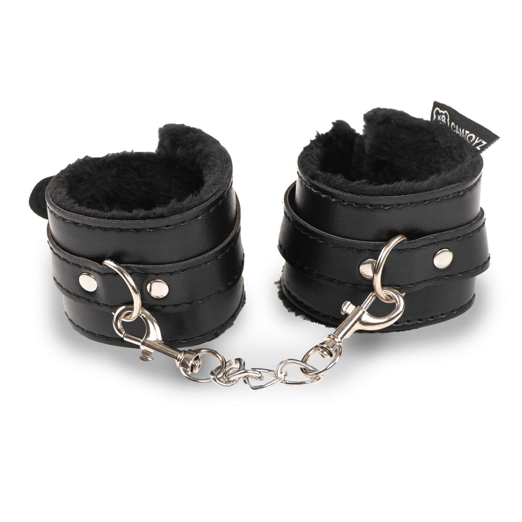 Esposas BDSM negras Feraly de la marca Camtoyz, hechas de material resistente y con cierre metálico para juegos de restricción.