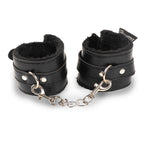 Esposas BDSM negras Feraly de la marca Camtoyz, hechas de material resistente y con cierre metálico para juegos de restricción.