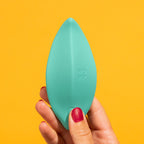 Estimulador de clítoris Romp Wave en color turquesa, succionador portátil con diseño ergonómico y texturizado para placer.